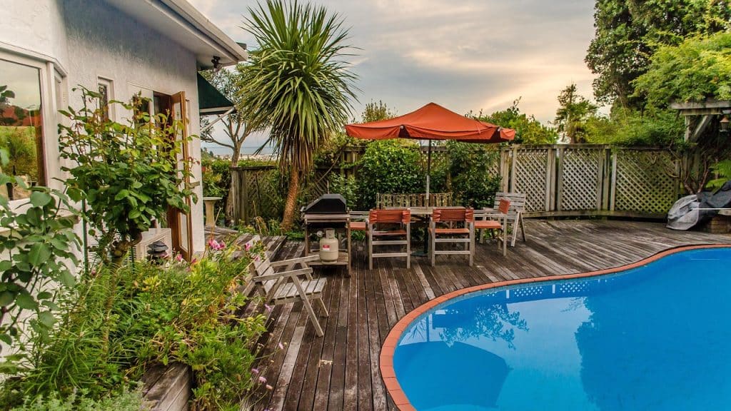 Un beau jardin aménagé avec une piscine et une terrasse en bois