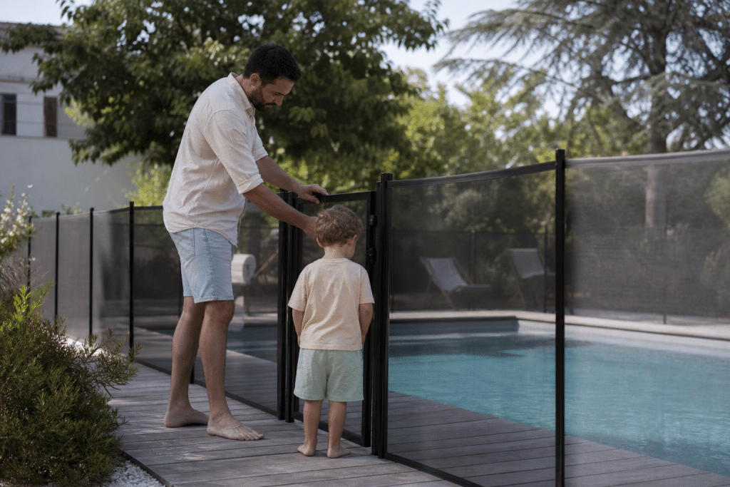 Homme installant une barrière de sécurité piscine avec enfant